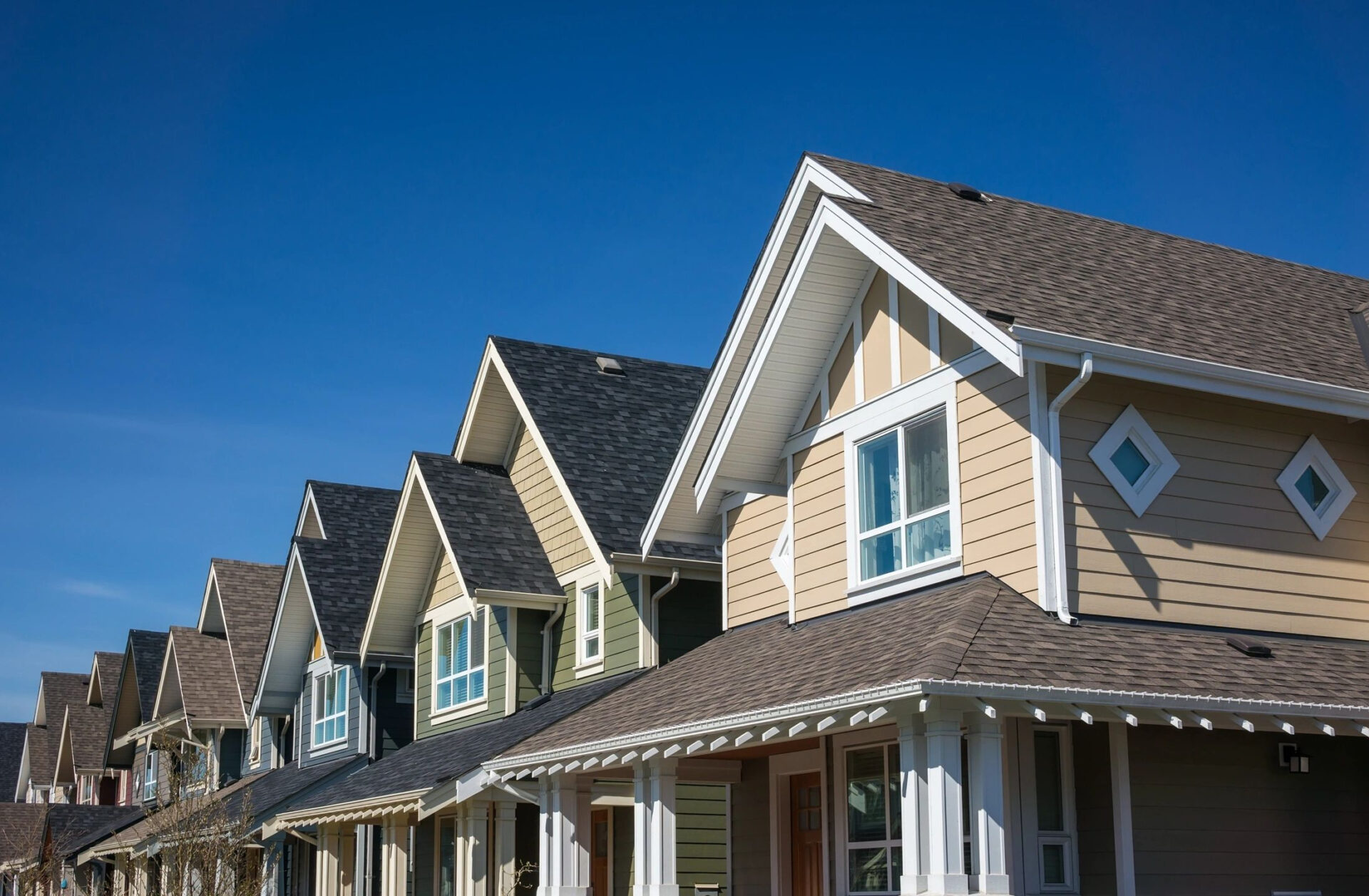 A row of houses with a blue sky in the background.