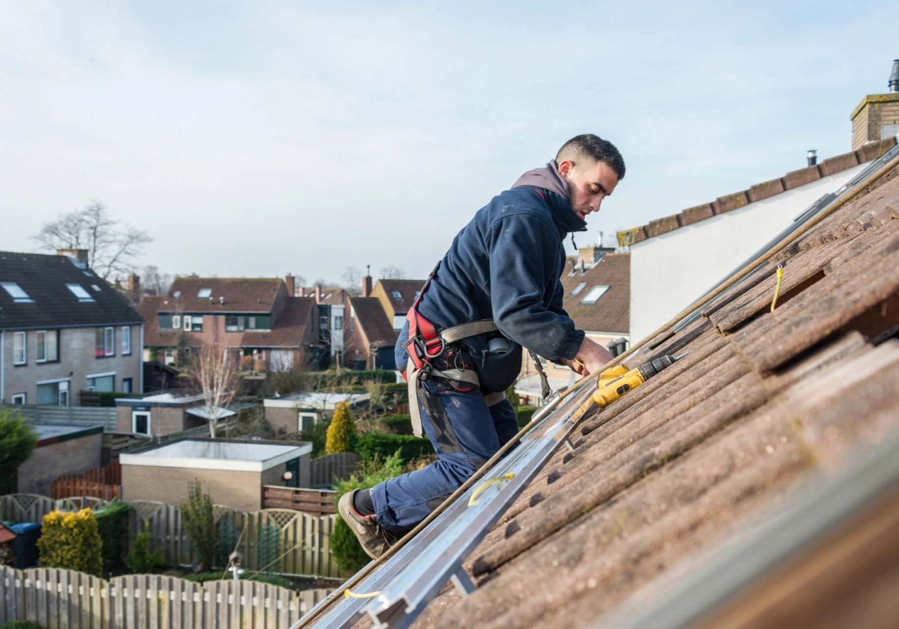 A man working on the roof of his house.